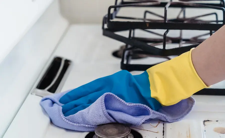 Limpieza de los fogones de la cocina con guantes