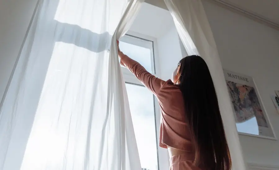 Ventilación de la vivienda abriendo las cortinas en primavera
